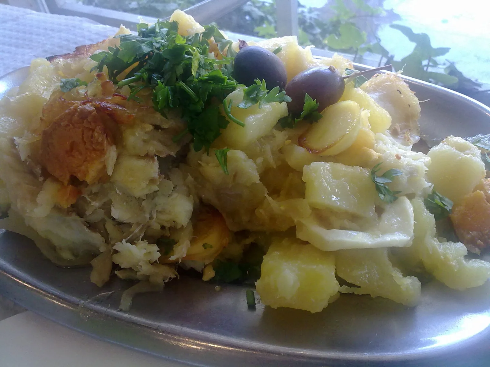 Bacalhau a Gomes de Sa with cod, potatoes, onion, olives, and egg.