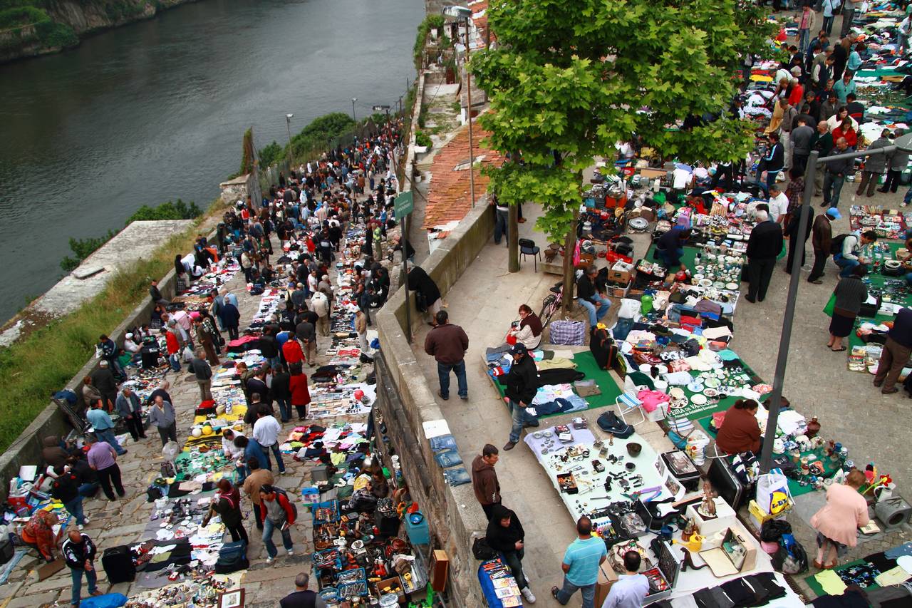 Feira da Vandoma flea market tables in Porto.