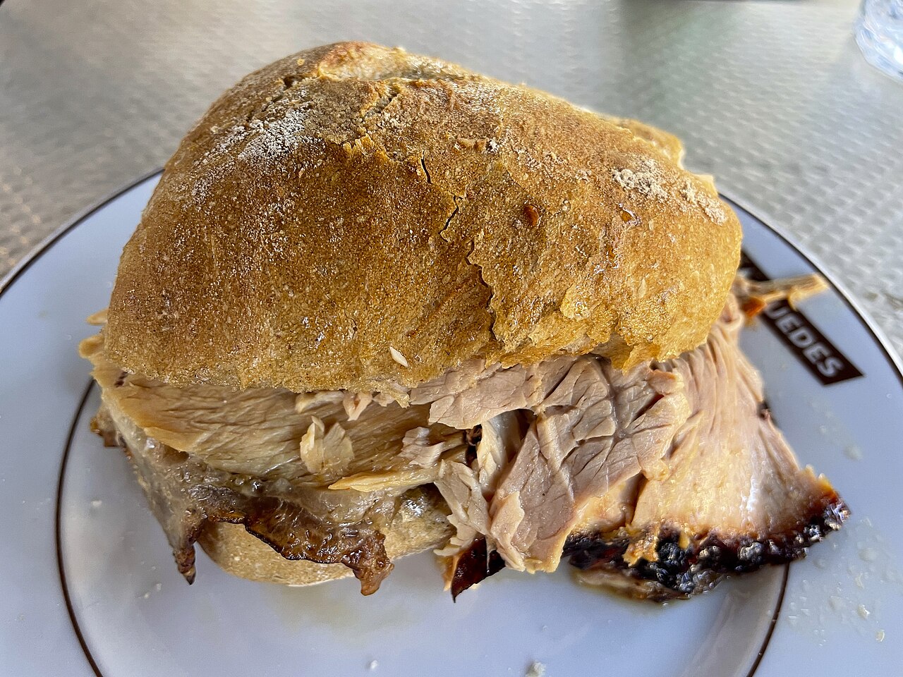 A roast pork sandwich photographed at Casa Guedes in Porto.