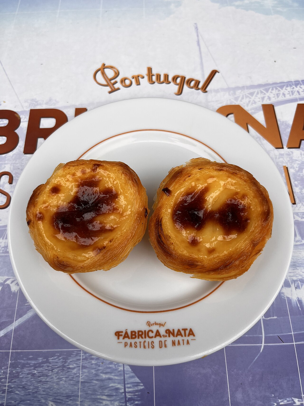 Two pastel de nata custard tarts photographed at Fabrica da Nata in Porto.