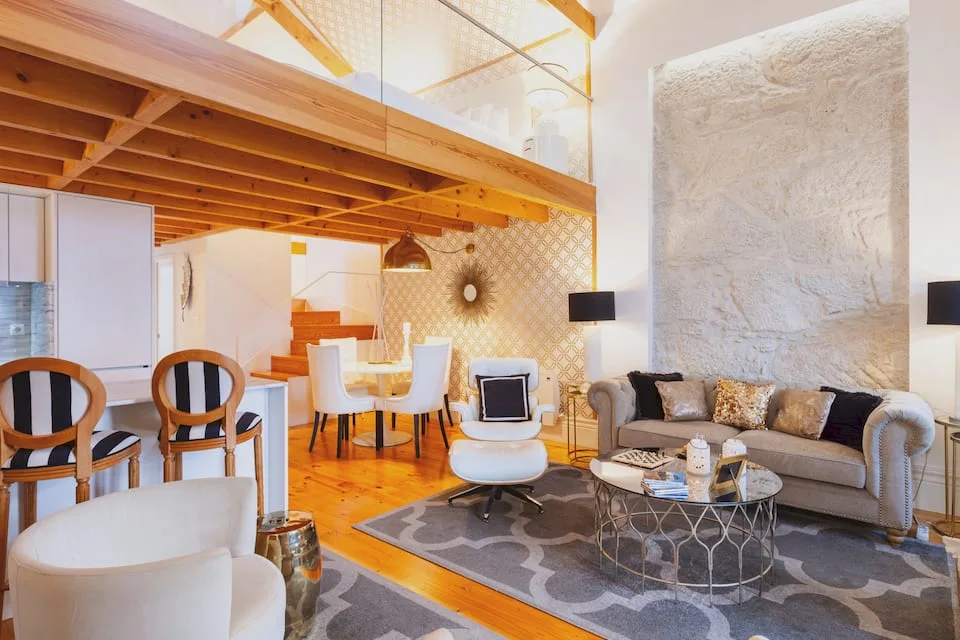 Sofas, dining area and exposed wooden mezzanine in Oporto Golden Apartment.